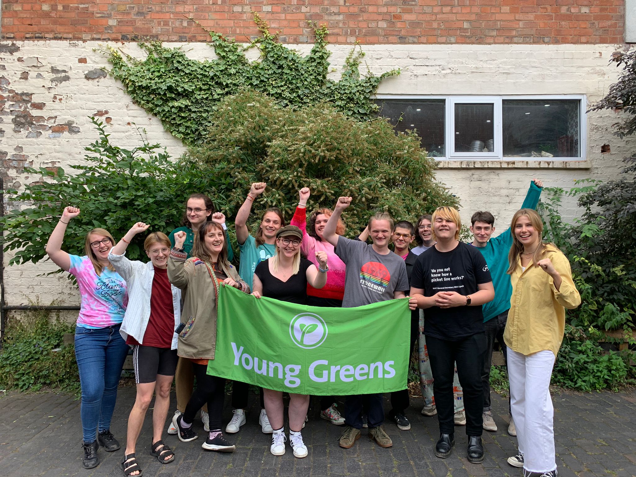 The Young Greens Executive Committee stood with the Young Greens banner and their fists raised.