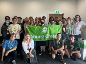 Group of Young Greens at Convention 2022. They're holding the Young Greens banner and are all smiling.