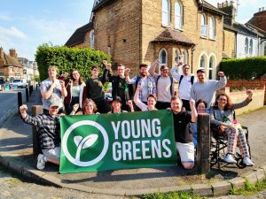 Group of Young Greens in Oxford with the Young Greens banner. They're all smiling with their fists raised