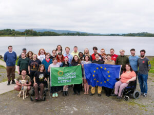 Group of Young Greens stood in front of a lake with the FYEG and EU flags