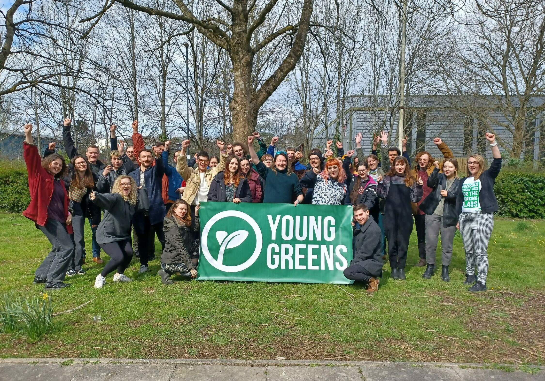30 Under 30 Graduates from 2022 holding the Young Greens banner with their fists raised