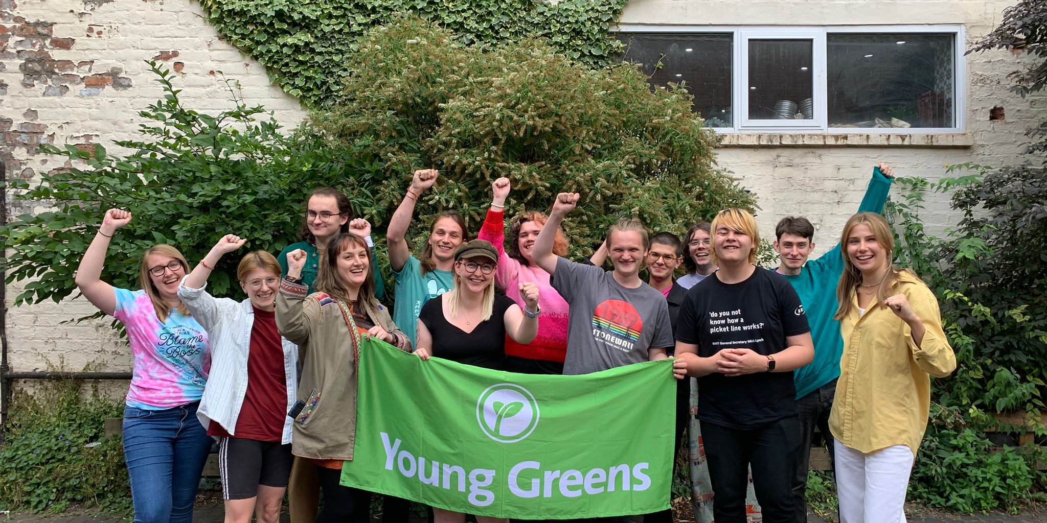 The Young Greens Executive Committee stood with the Young Greens banner and their fists raised.