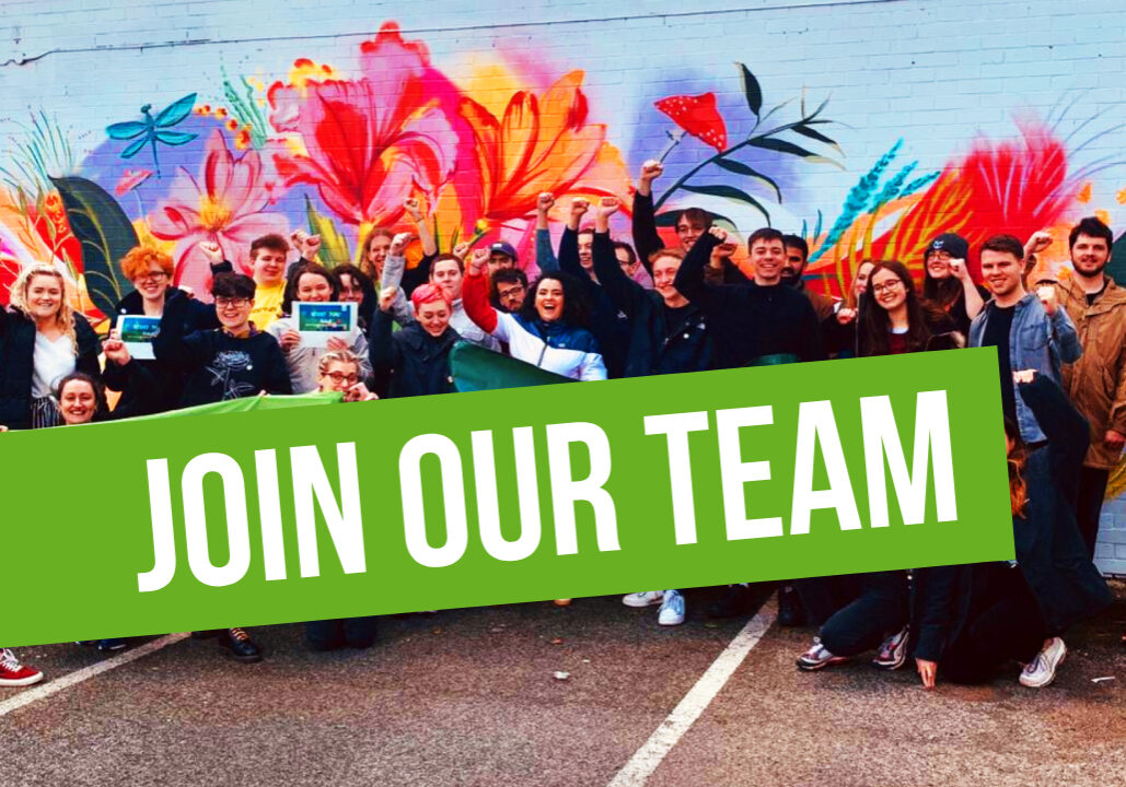 Join our team! img: young greens with fists in the air in front of colourful mural