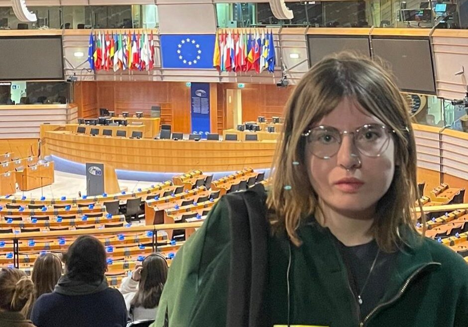 Olivia looking to camera in front of European Parliament